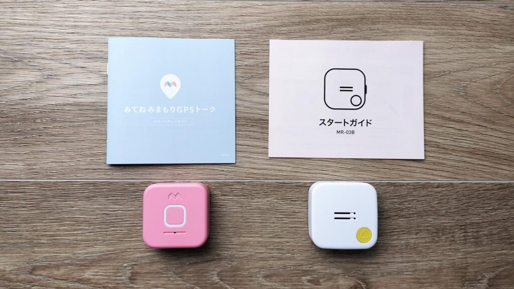 家族が2つのトーク付き子ども用GPSのパンフレットを見比べながら、どちらを選ぶか相談している様子の写真。