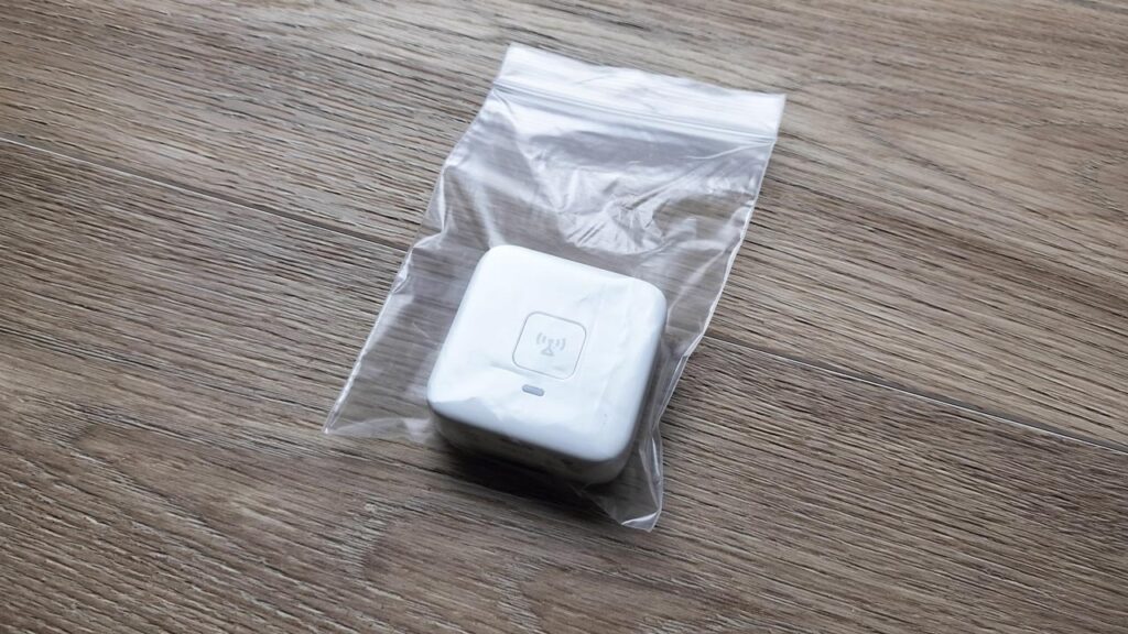 透明のチャック袋に子ども用GPS端末を入れ、ボタン部分が外から見える状態の写真。