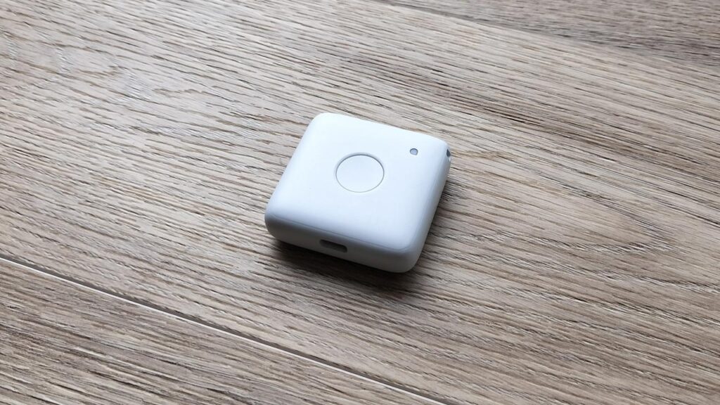 まもサーチ3の子どもGPS端末と、位置情報が表示されたスマホ画面を並べて撮影した写真。