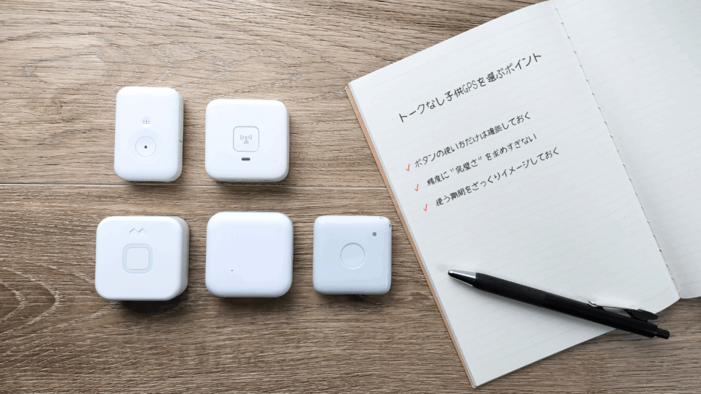 子どもGPSの注意点をメモしたノートと赤ペン。月額料金や電池持ち、ボタンの使い方などが書かれている。
